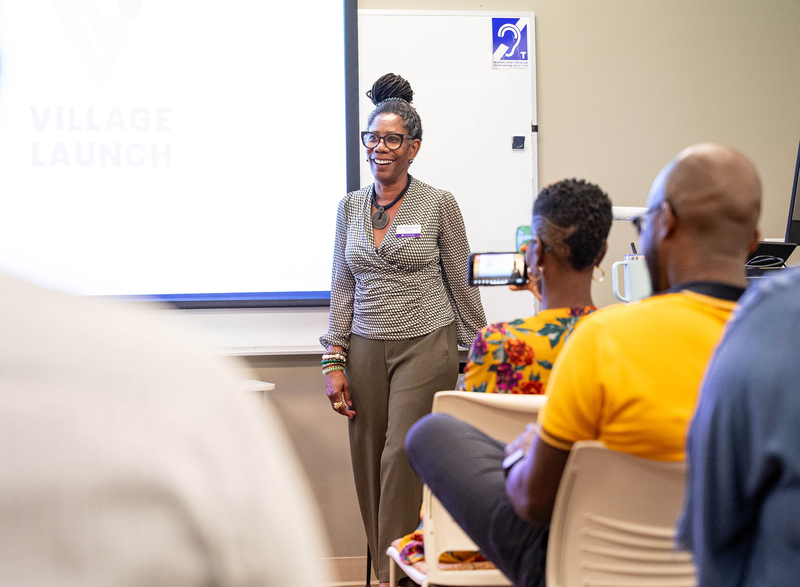 Dr. Judith Williams addresses attendees of Photovoice student presentation