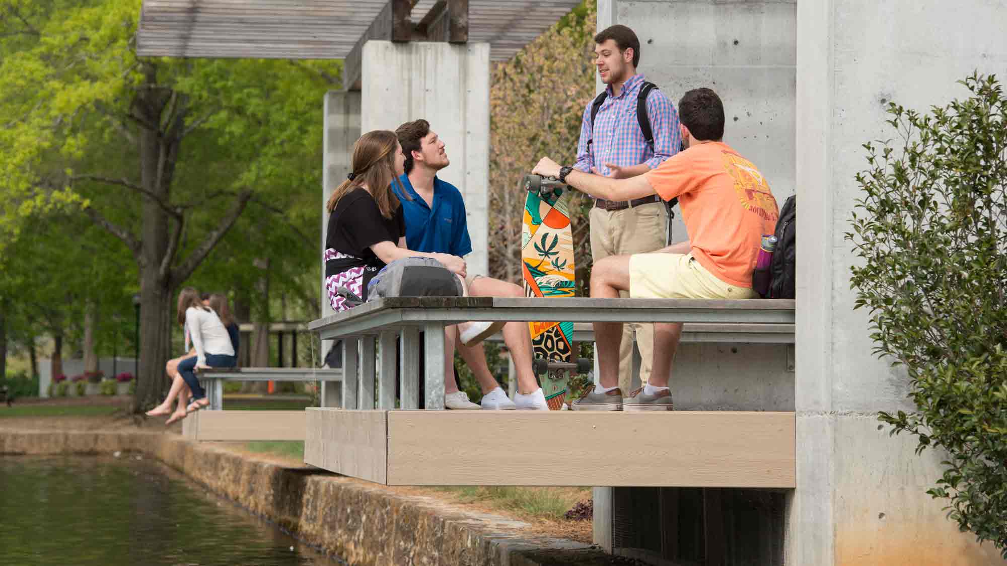 Students outside sitting near the lake