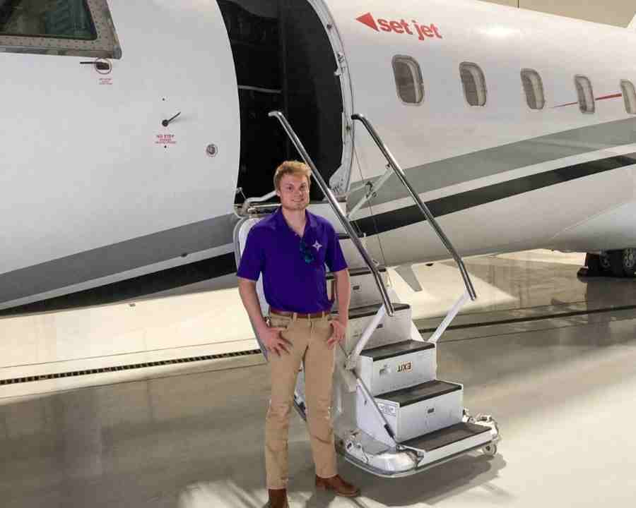 Furman intern standing in front of a plane