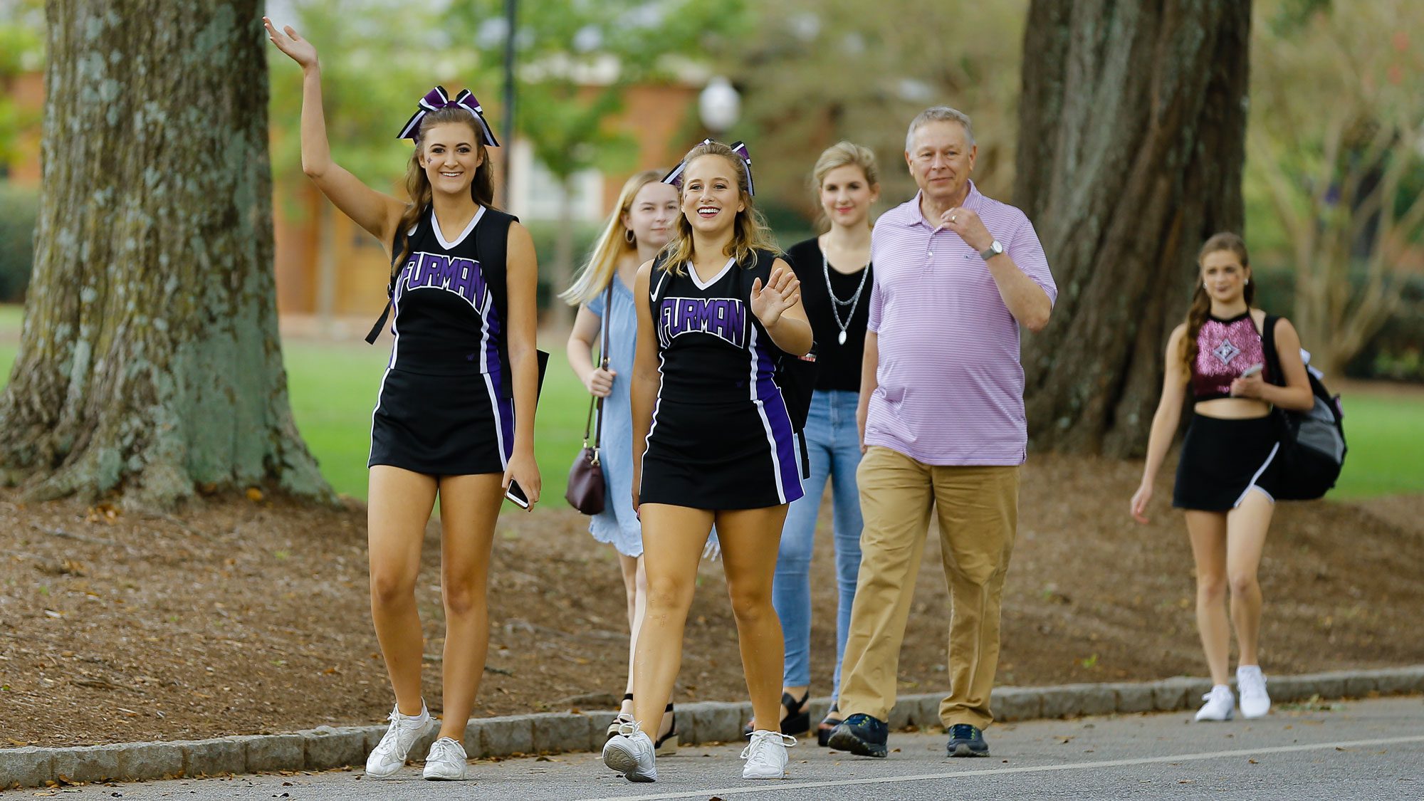Cheerleaders walking down the mall with parents