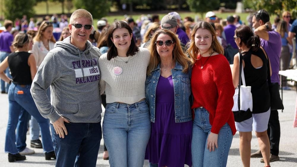Family smiling together at Furman tailgate