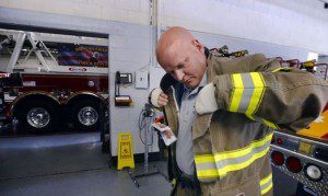 Kirk Fisher dons his volunteer firefighter suit
