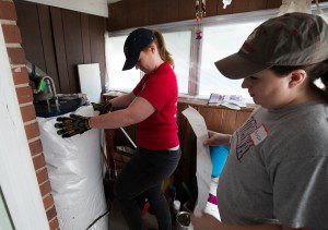 Volunteers wrap the water heater with insulation.