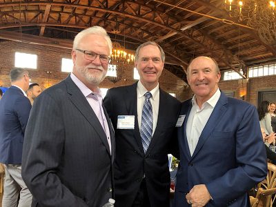 three white men at event, John Yates (center)