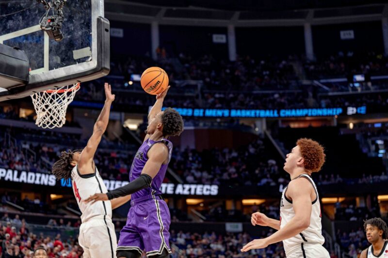 Furman basketball player reaching to the basket