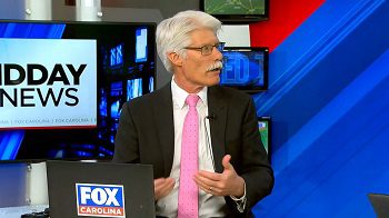 white man wearing glasses and suit on TV set, Brent Nelsen