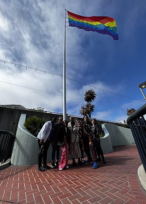 Furman students pose in front of a Pride flag during a tour of the Castro district in San Francisco.