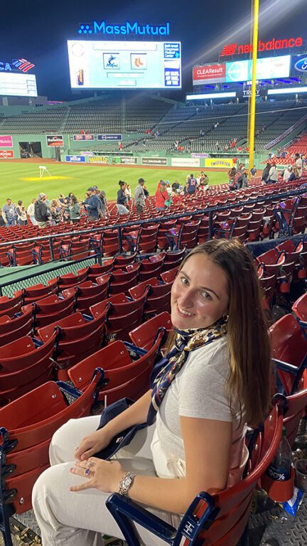 Photo of a woman sitting in the stands at a major league baseball game.