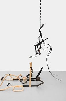 found art with random pipes, wires, a magnifying glass and other elements.