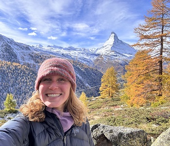 white woman poses in front of mountain range