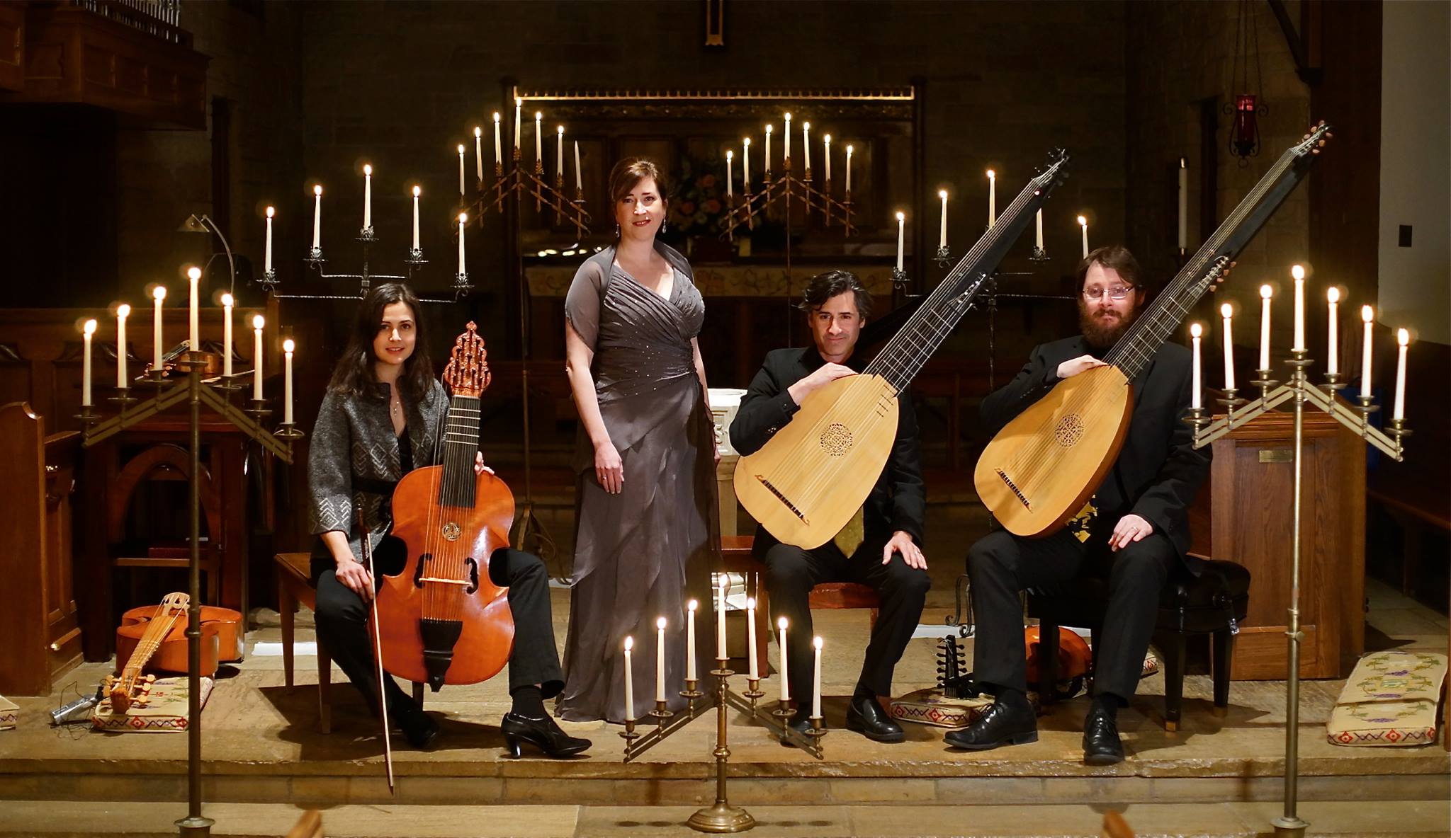 ensemble members on stage with candelabras in background