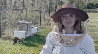 white woman wearing bee-keeping clothing