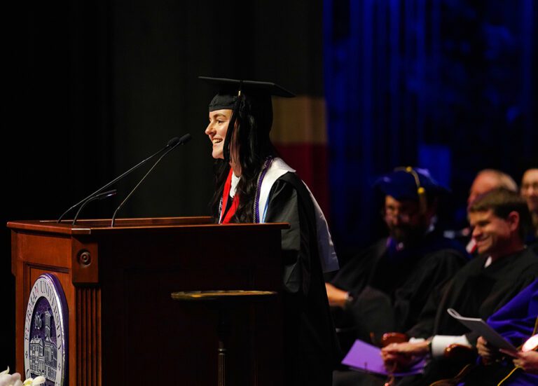 A graduate speaks at a lectern.