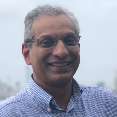 Indian man wearing glasses.