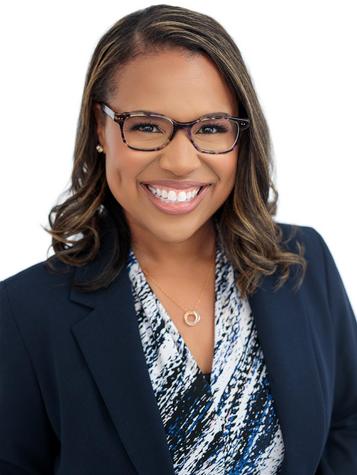 Black woman wearing glasses and dark blazer