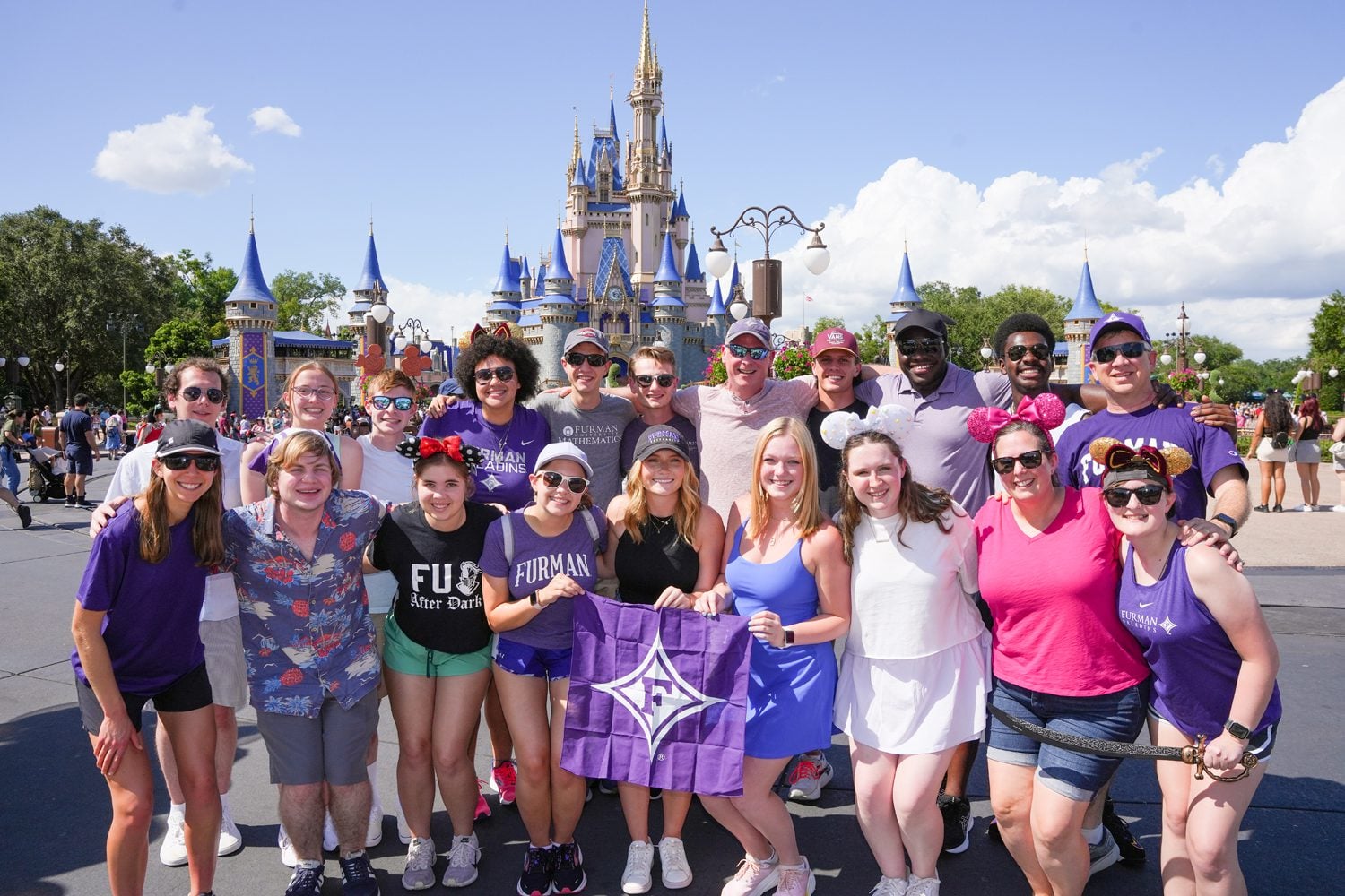 Furman students and math professors participating in the Math and the Mouse May X have their photo take in the Magic Kindown at Disney World on Monday, May 20, 2024. Photo by Nathan Gray, Furman University.