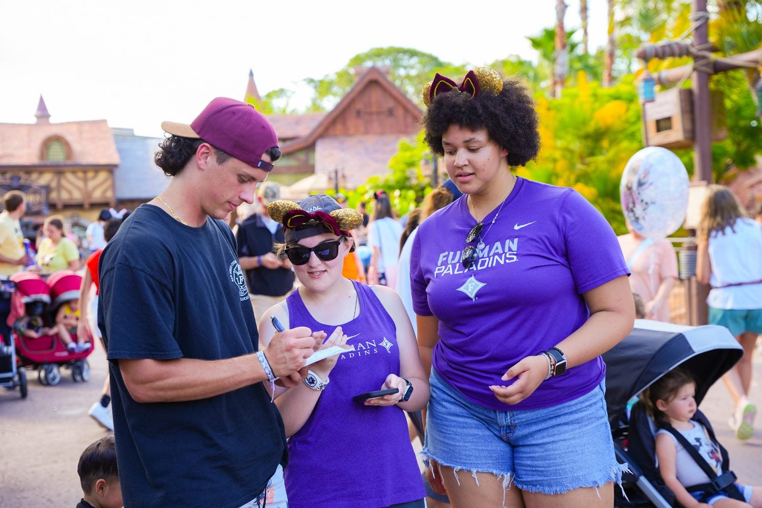 From left, John Taylor ’27, Morgan Carns ’25, and Savannah Bailey ’27 collect data outside of an attraction at Disney World. Photo by Nathan Gray, Furman University.