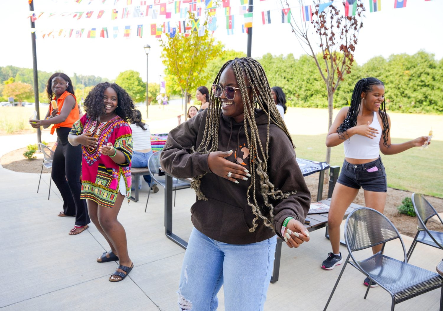 Members of the student group Afrikiya dance together on a patio of Lakeview Hall during the grand opening celebration for the Center for Interpersonal Connections on Monday, August 26, 2024. Photo by Nathan Gray, Furman University.