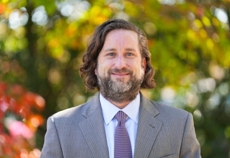 Portrait of a white man with long brown hair and a beard.