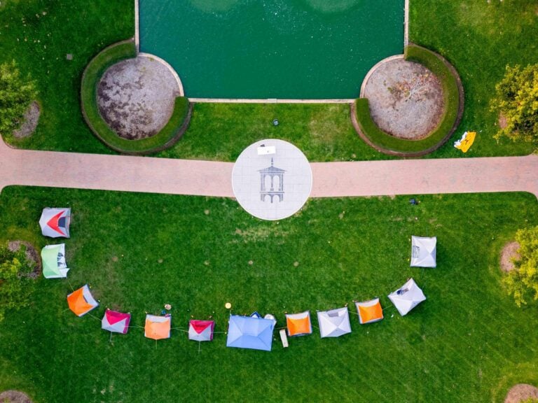 An overhead view of a row of tents on Furman University's Milford Mall, a lawn that houses a reflecting pool.