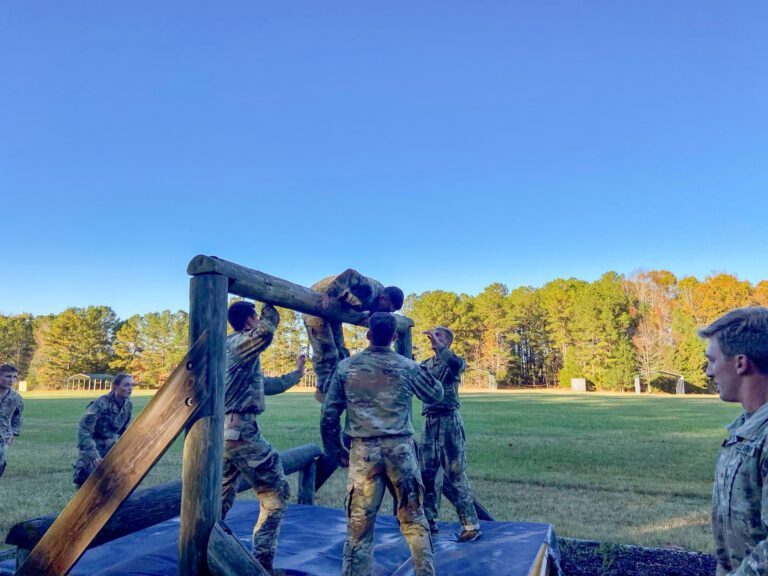 Cadets run an obstacle course in early morning light. 