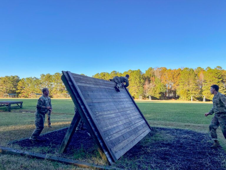 Cadets run an obstacle course in early morning light.