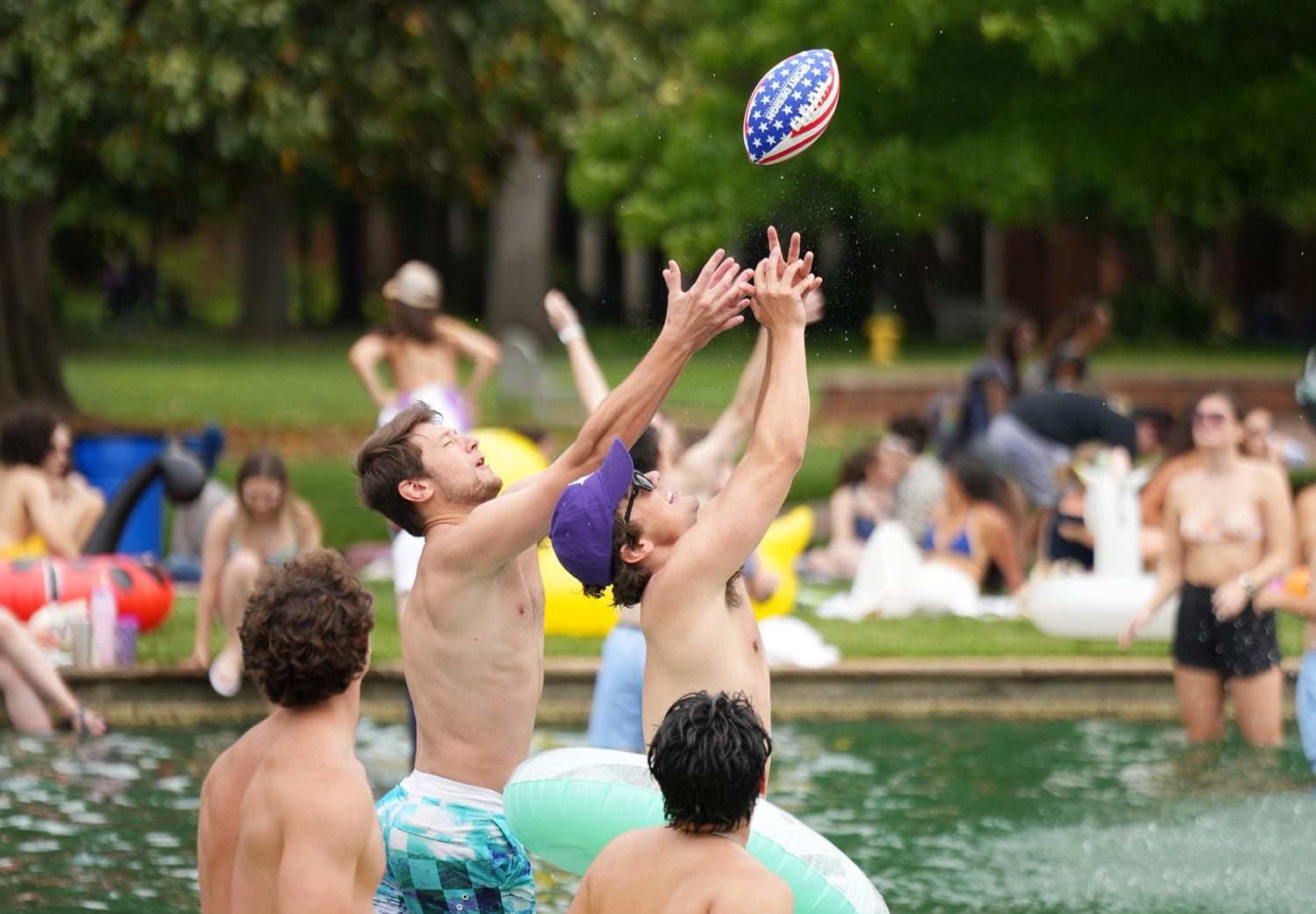 Students jump for a football in the fountain on Milford Mall during LDCO on Tuesday, April 29, 2025.