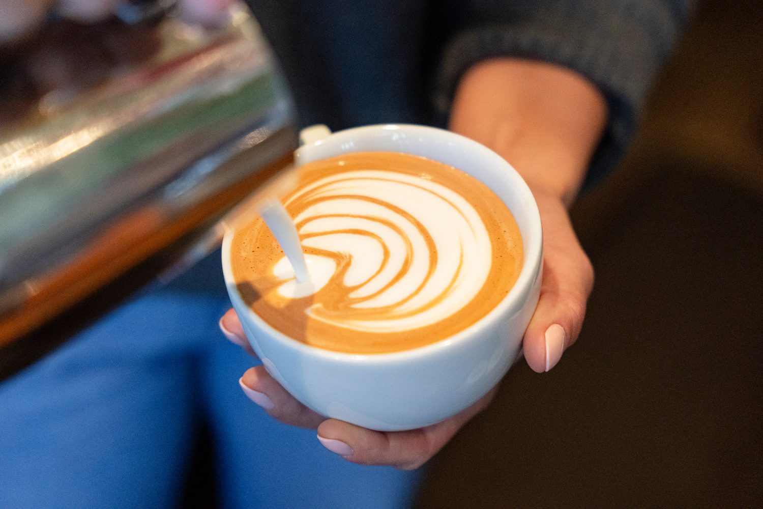 Deb York ’14 pours a latte at Grateful Brew. Photo by Owen Withycombe.