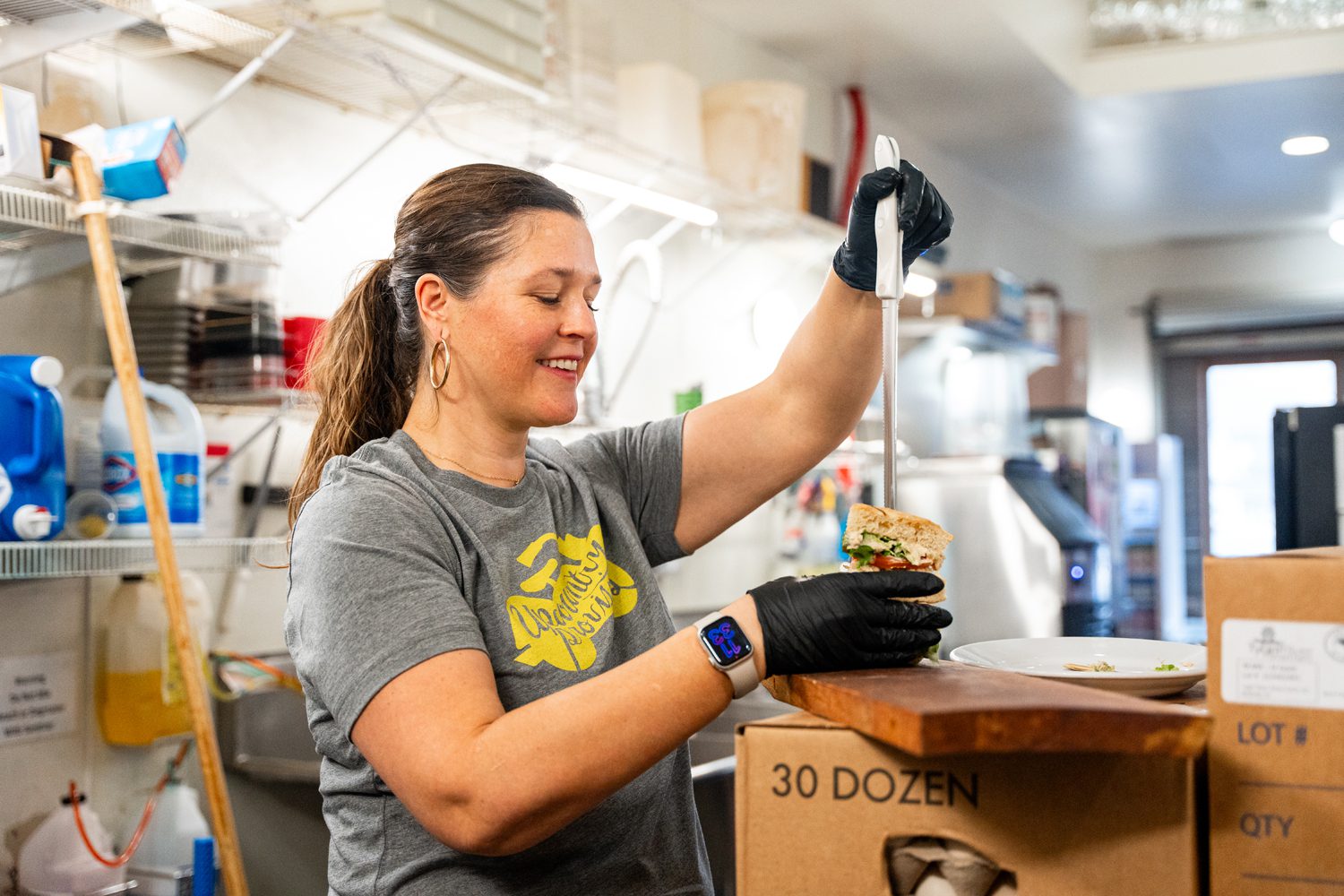 Cheryl Kraus ’09, owner of Upcountry Provisions, prepares a sandwich. Photo by Owen Withycombe.