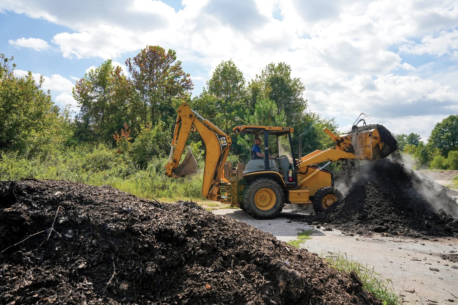 Bruce Adams, manager of the Furman Farm at The Shi Institute for Sustainable Communities, operates a backhoe to turn piles of compost at an off-campus compositing site on September 19, 2024. Photo by Nathan Gray