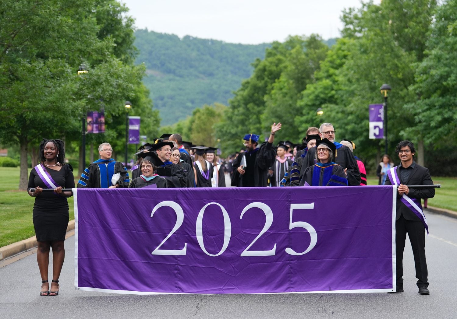 Students celebrate while walking from McAlister Auditorium to Paladin Stadium at the start of the commencement ceremony on May 10.