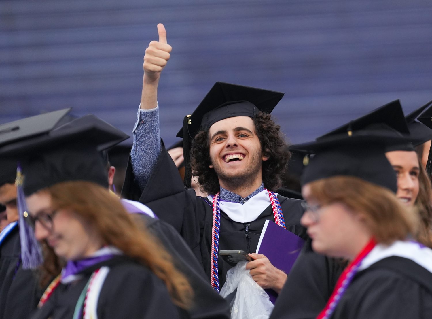 Seth Jones ’25 gives a thumbs to the crowd while taking his seat in Paladin Stadium at the start of the commencement ceremony on May 10.