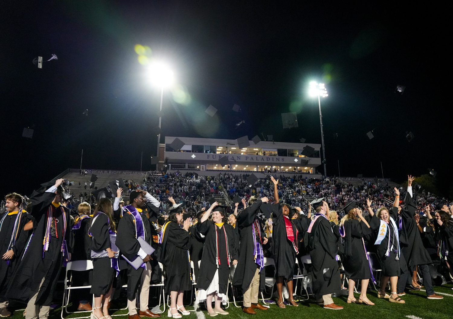 Graduates throw their caps in the air following the conclusion of the 2025 Commencement Ceremony in Paladin Stadium on May 10.