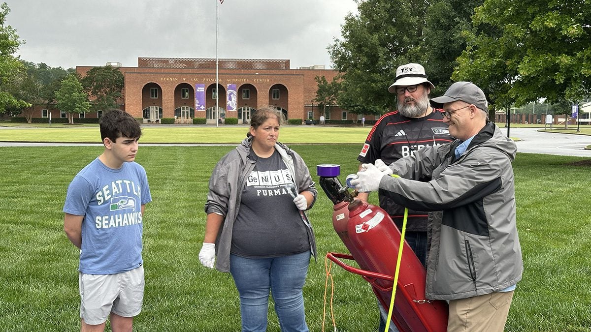 Teddy Fields, a JL Mann High School student, Courtney Kucera, lab manager in the Department of Physics, Bob Anderson '17, a physics teacher at JL Mann, and David Moffett, professor of physics, inflate the balloon.