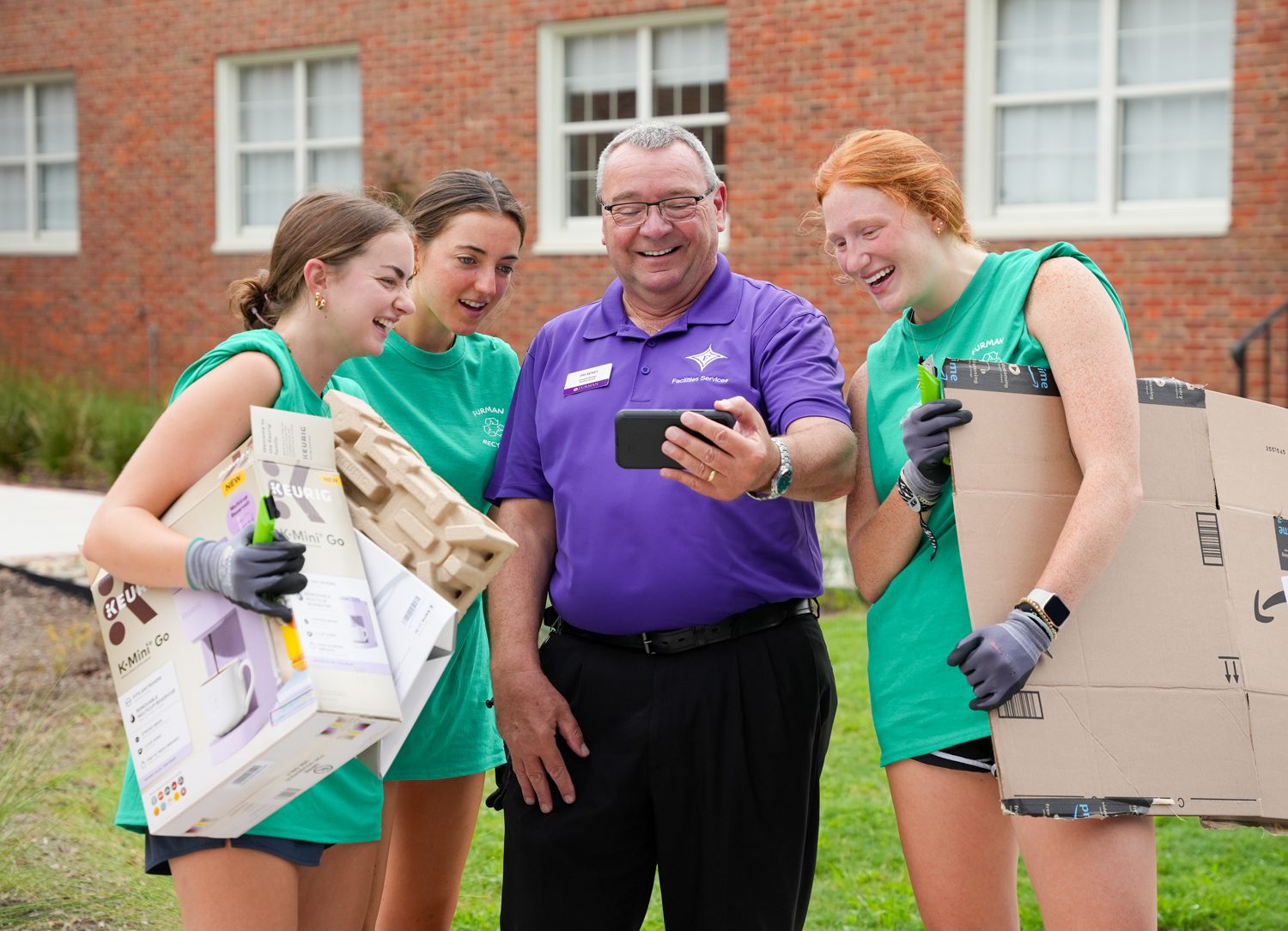 Jim Benes, known as “Mr. Jim,” shows a video to current students who were helping break down boxes to be recycled during move-in day on Thursday, Aug. 21, 2025.