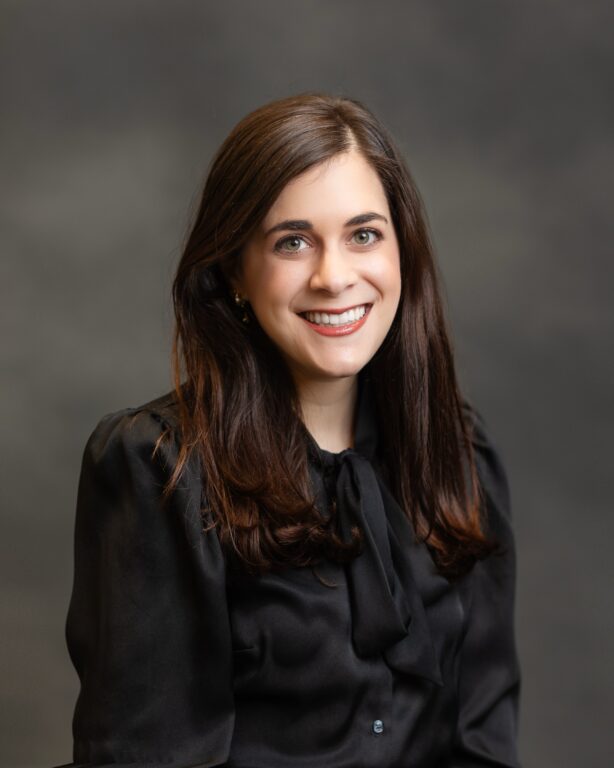 A portrait of a white woman in a black shirt.