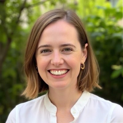 A portrait of a white woman wearing a white shirt.