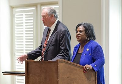 A white man and a Black woman wear business attire and stand at a podium. Harry Shucker, Order of the Palmetto