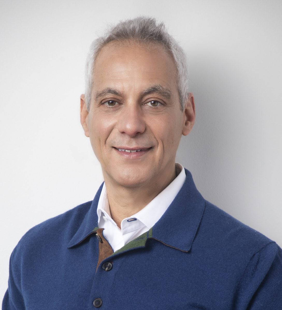A white man with gray hair wears a blue sweater. Rahm Emmanuel