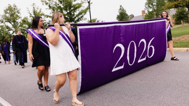 A 2026 banner leads the procession toward McAlister Auditorium for the Opening Convocation ceremony.