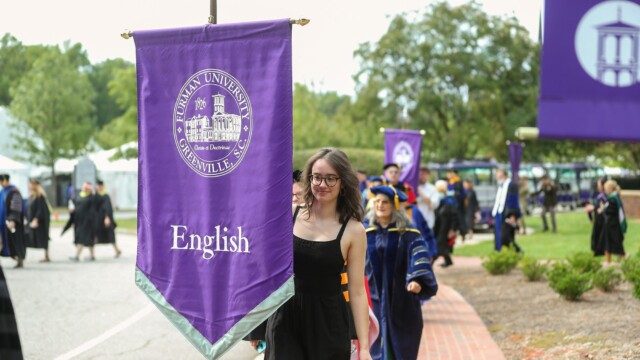 Laura Dame ’23 carries the banner of the English Department into McAlister Auditorium for the Opening Convocation.