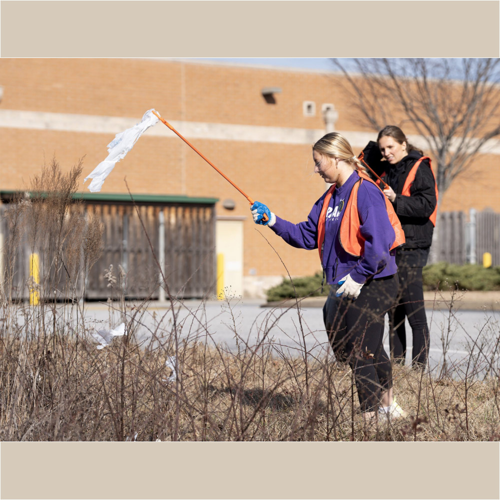 Furman volleyball team members Nicole Swindle '25 and Gráinne McGrath '26 help pick up trash along Krieger Drive in Travelers Rest.