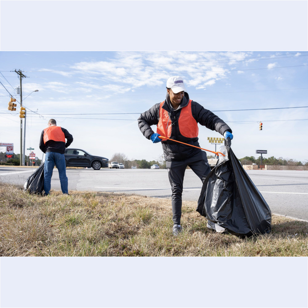 Furman men’s soccer player Christian Newman ’24 and Denison Jones ’24 help pick up trash along US Highway 25 in Travelers Rest as part of the MLK Day of Service on Monday, January 16, 2023.