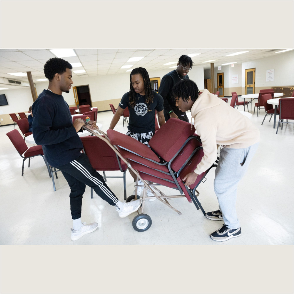 From left, Jonathan Luines ’26, Jalen Livingston ’25, Victor Nnodim ’26, and Chase Sledge ’26, stack chairs at Springfield Baptist Church in Greenville as part of the MLK Day of Service on Monday, January 16, 2023.