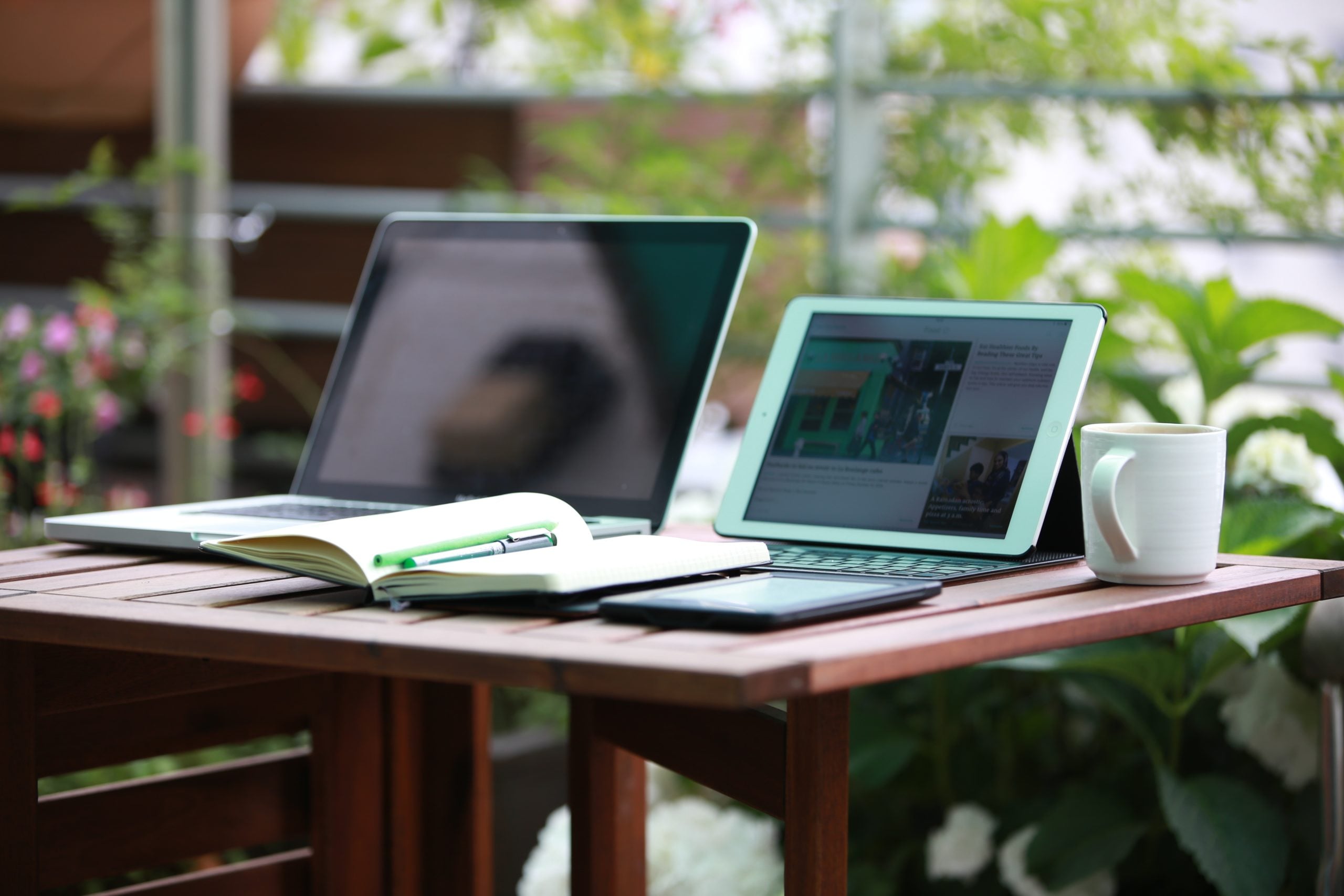 laptops, pens, and coffee cup on a table