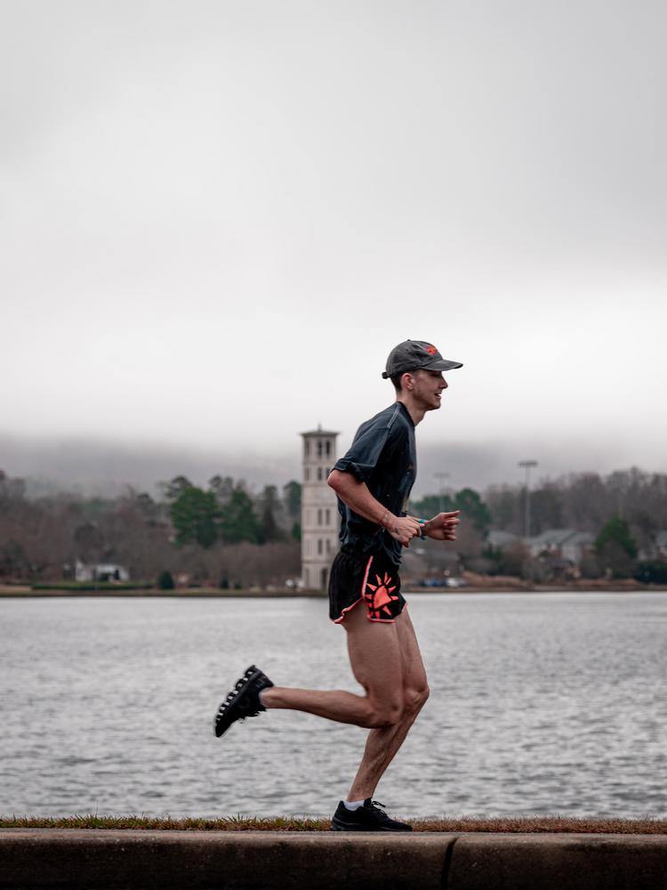 Man jogging around lake in fog