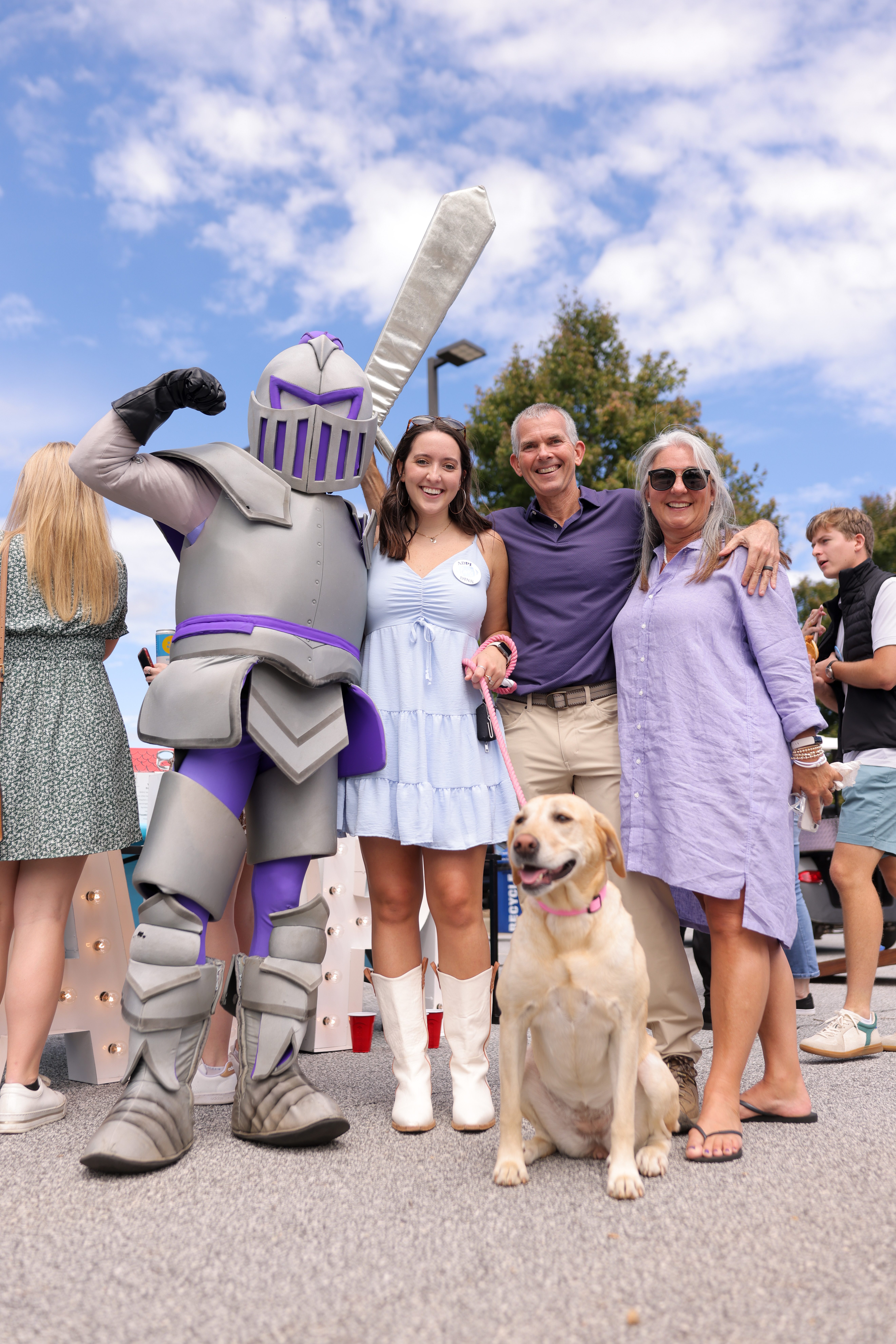 family of three, young woman with middle aged parents, white dog, paladin mascot