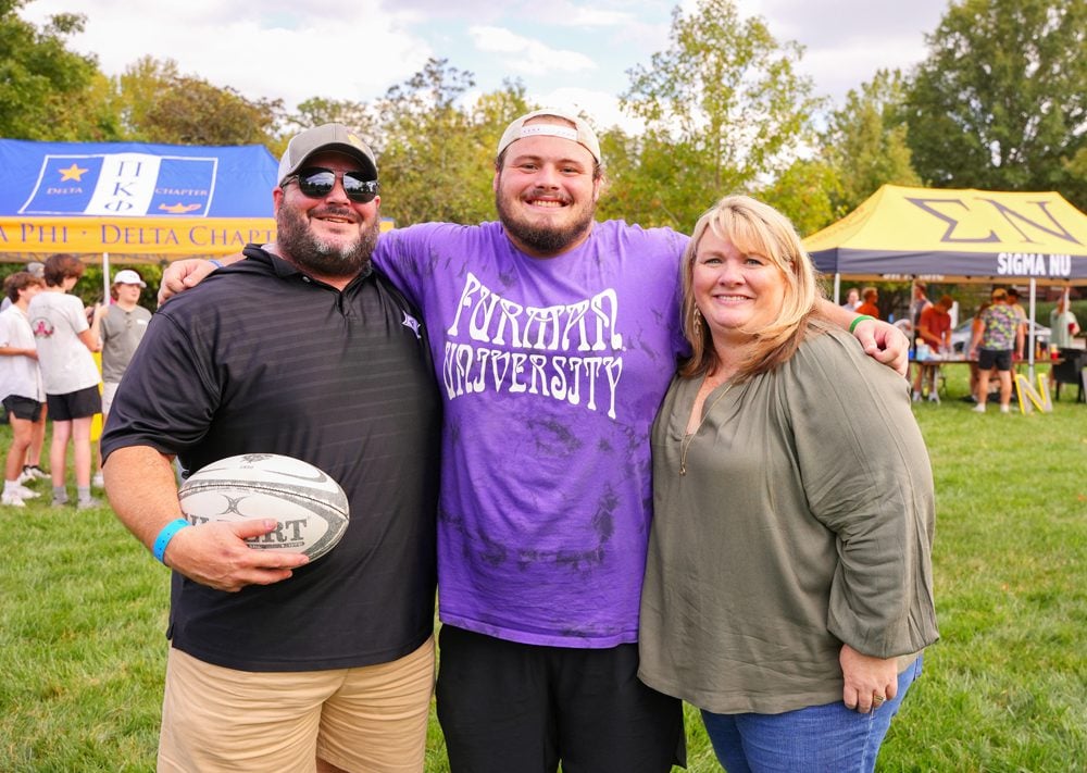Student and his parents during Family Weekend at a football game.