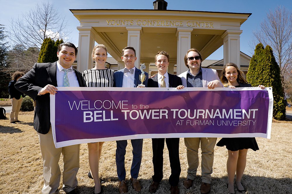 Mock Trial team members hold Bell Tower Tournament banner