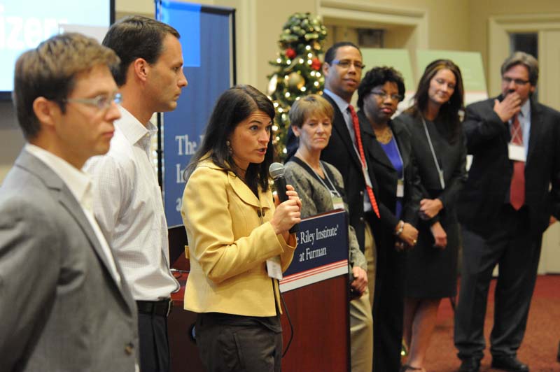 The Mobilizers: (l-r) Andreas Kalscheuer, David Lominack, April Buchanan (speaking), Ann Bourey, Paul Thompson, Arelis Moore de Peralta, Lynne Fowler and Michael Posey